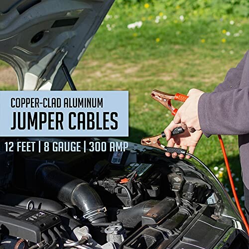 Person using copper-clad aluminum jumper cables on car engine.